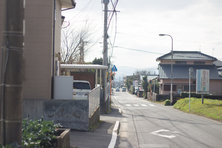 【写真】学園の近くにある道路。複数の一軒家があり、そこで暮らしている人がいるとわかる。