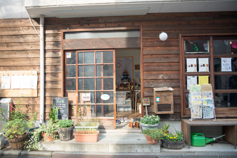 【写真】木でできた建物の玄関前には植物が植えられたプランターが並ぶ