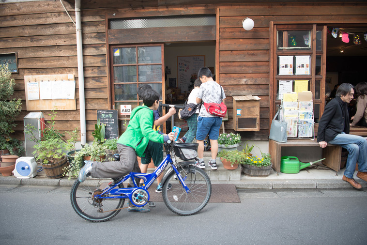 【写真】自転車にのって男の子が芝の家にやってきたところ。友人と待ち合わせをしているよう