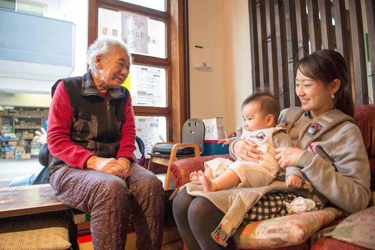 【写真】お母さんと膝の上に乗っている赤ちゃん、そして隣におばあちゃんが座っている。笑顔で微笑み合っている