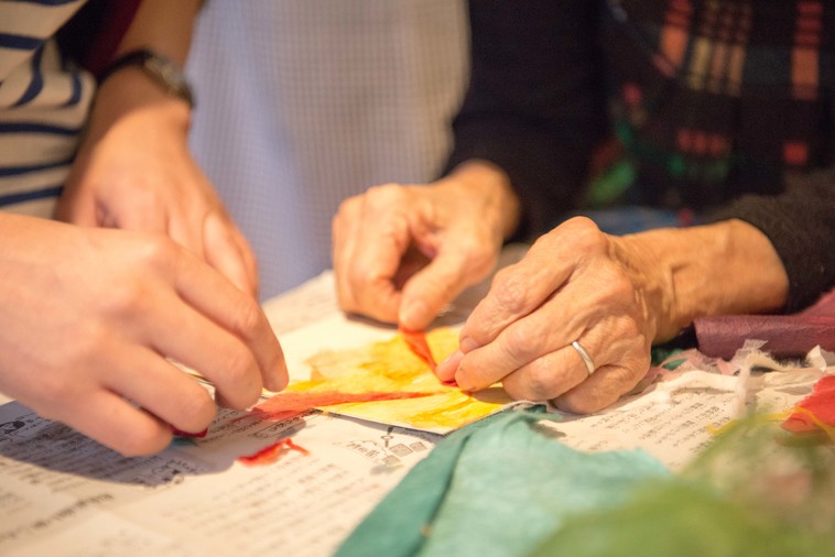 【写真】ちぎり絵のやり方を教わっている