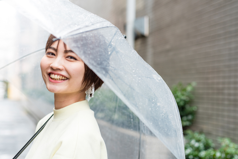 【写真】傘をさして笑顔で立っているたなかれいかさん
