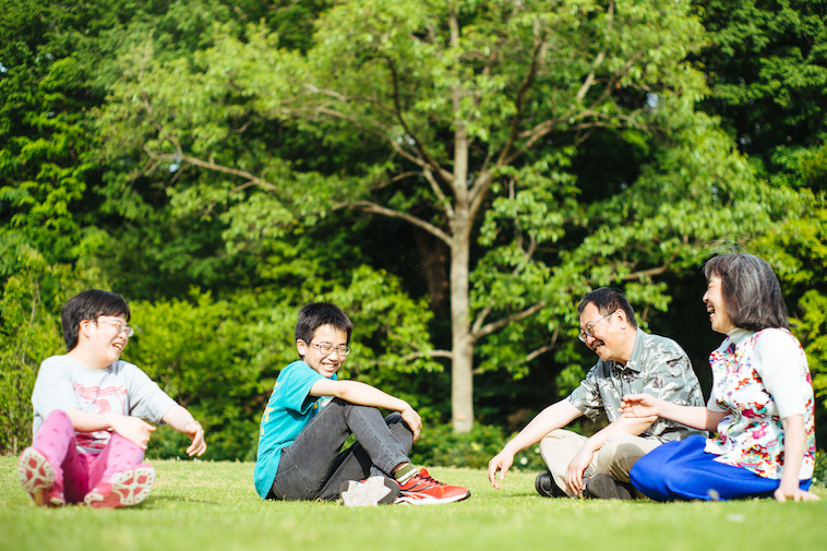 【写真】芝生に座り楽しそうに話すご家族
