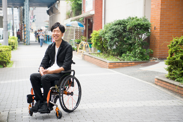 【写真】街頭で車椅子に座り満面の笑みをみせるみよたつやさん