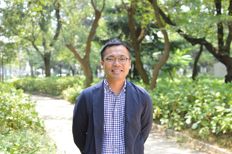 【写真】緑の木々を背景に立っているしおやまりょうさん