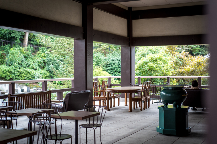 【写真】光明寺の一角。木製の椅子や机があり、木の柵の外側には森がある。