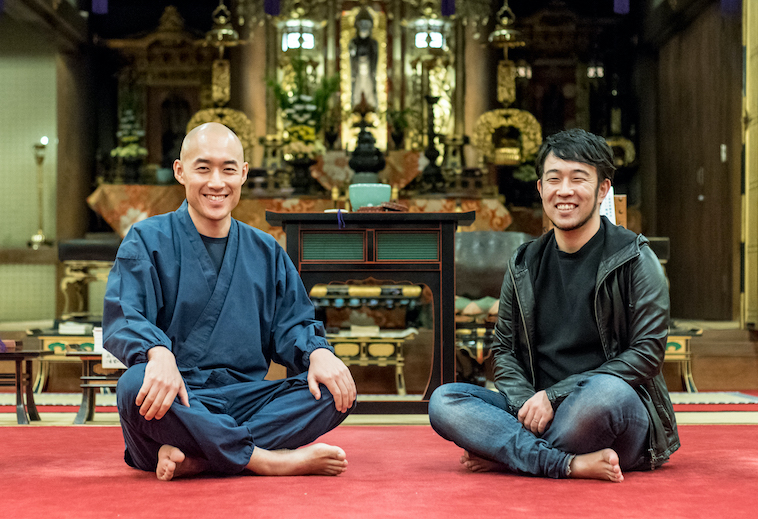 【写真】光明寺の本堂で足を組んで座り微笑んでいるまつもとしょうけいさんともりじゅんや