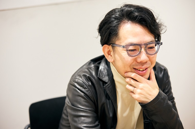 【写真】顎を左手で触りながら話すまつむらさん
