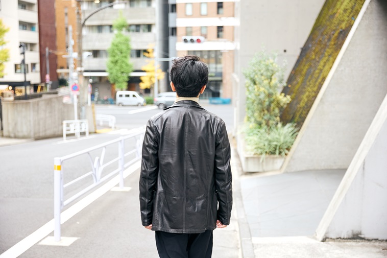 【写真】歩道を歩くまつむらさんの後ろ姿
