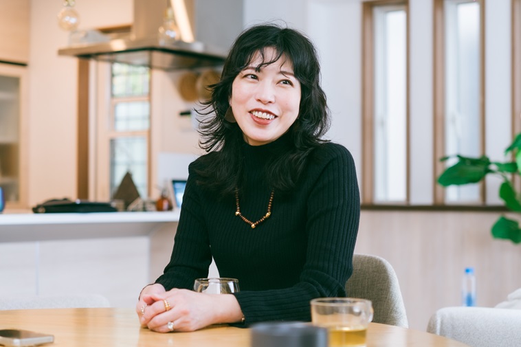 【写真】椅子に座り微笑みながらお話するさえこさん