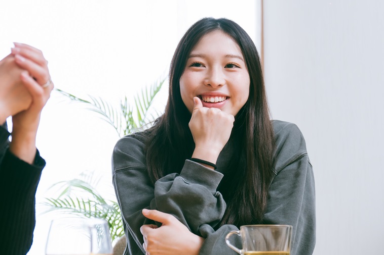 【写真】顎に右手を置きながら微笑むれいらさん