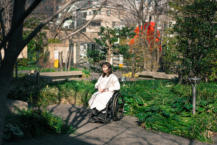 【写真】車いすに乗って笑顔でこちらを見ているうめつさん