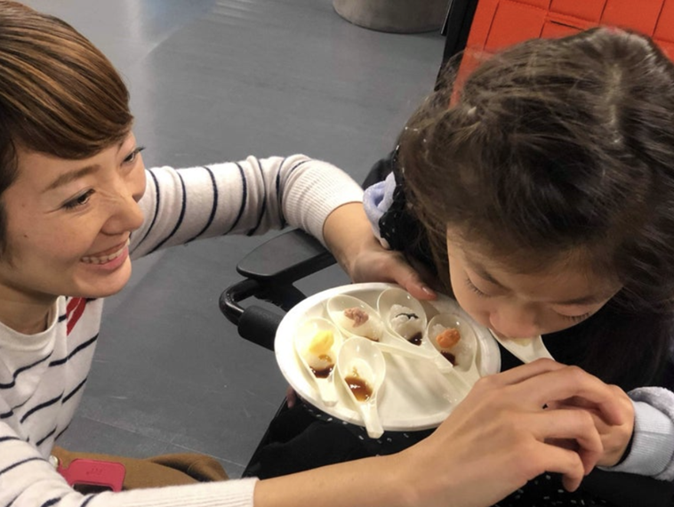 【写真】にぎらな寿司を食べるまこさんと、笑顔で見つめる母のかとうさくらさん