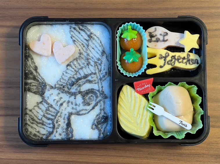 【写真】ハート型やフォーク型に切り抜かれたおかずがあるお弁当。ご飯に鳥が描かれている。