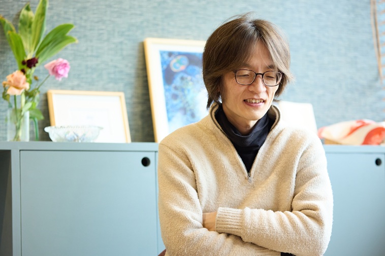 【写真】両腕を組み、少しうつむきながら話すもりかわさん