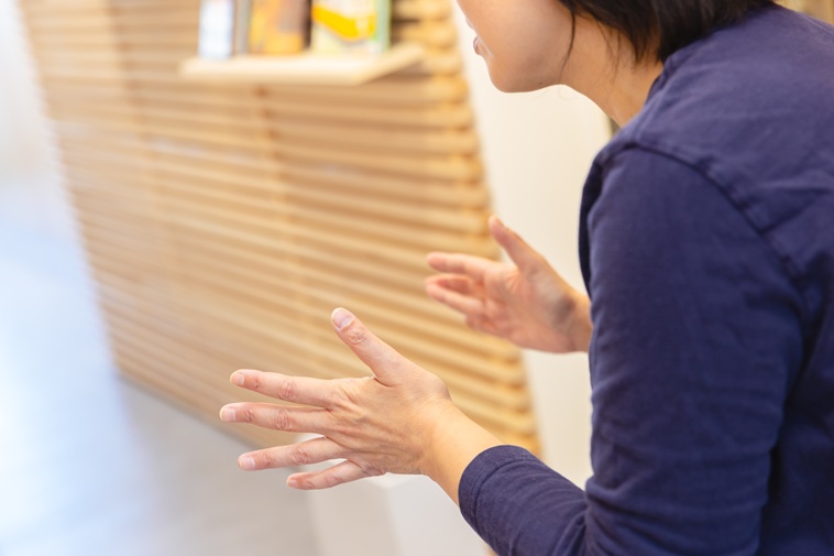 【写真】インタビューにこたえるたなかせんせいの横顔と手元