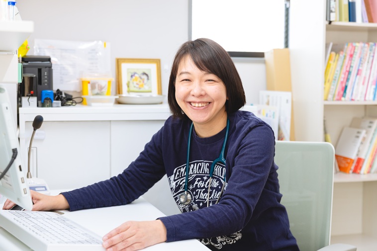 【写真】診察室の椅子に座り笑顔をみせるたなかじゅんこせんせい