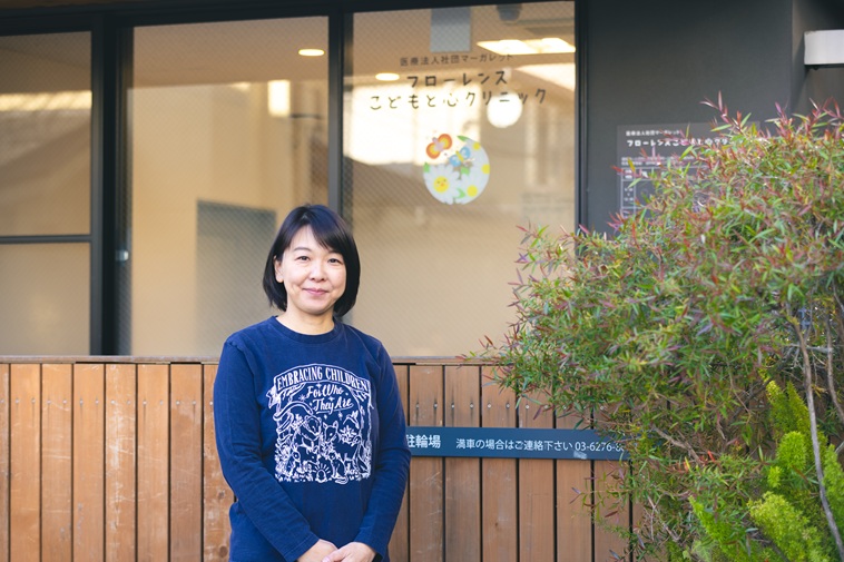 【写真】クリニックの前でカメラを見つめるたなかせんせい