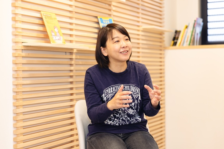 【写真】椅子に座り微笑みながら話すたなかせんせい