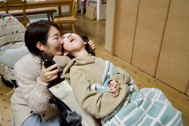 【写真】バギーに乗ったマコさんに頬を寄せるさくらさん