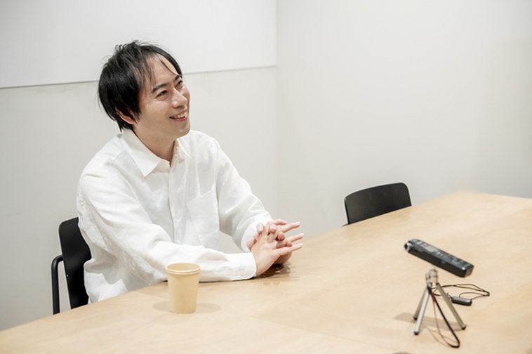 【写真】椅子に座り、インタビュアーに笑顔を向けるひろさん