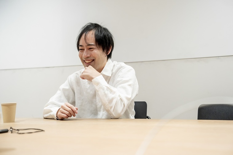 【写真】顎に左手を当て、笑顔でお話しするひろさん