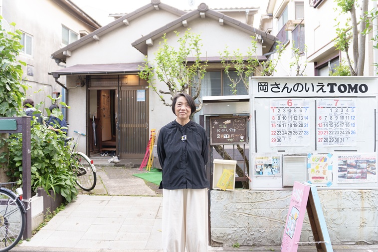 【写真】岡さんのいえの建物前で微笑むこいけさん