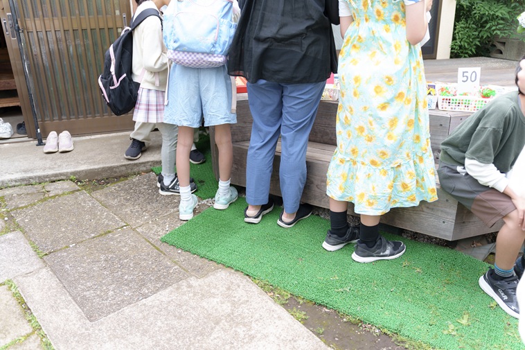 【写真】駄菓子の前に並ぶ子どもたちの足元