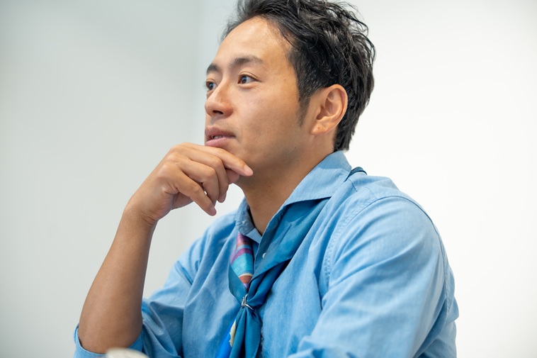 【写真】右手で顎を触りながら話すあらいさん