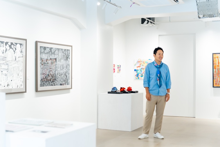 【写真】ヘラルボニーの作品に囲まれながら話すあらいさん