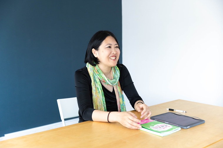 【写真】椅子に座り笑顔をみせるふじきさん